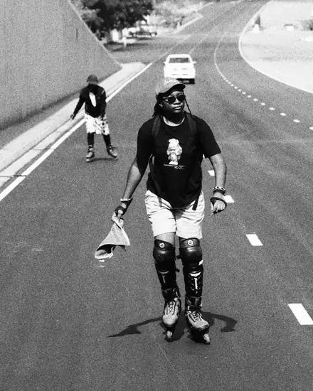 Dodoo inline skating down an empty road